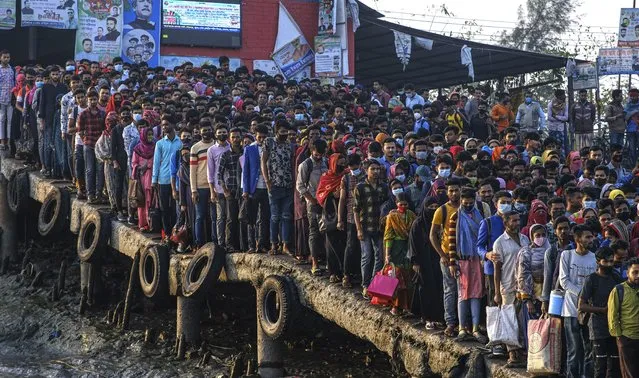 Workers gather in the morning at a boat terminal, waiting to cross the Mongla river, in Mongla, Bangladesh, March 3, 2022. This Bangladeshi town, located near the world’s largest mangrove forest Sundarbans, stands alone to offer new life to thousands of climate migrants. The town was once vulnerable to floods and river erosion. Now it has become more resilient with improved infrastructure and special economic zones to support climate migrants. (Photo by Mahmud Hossain Opu/AP Photo)