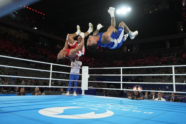 Uzbekistan's Abdumalik Khalokov and Australia's Charlie Senior flip after Khalokov won their men's 57 kg semifinal boxing match at the 2024 Summer Olympics, Thursday, August 8, 2024, in Paris, France. (Photo by John Locher/AP Photo)