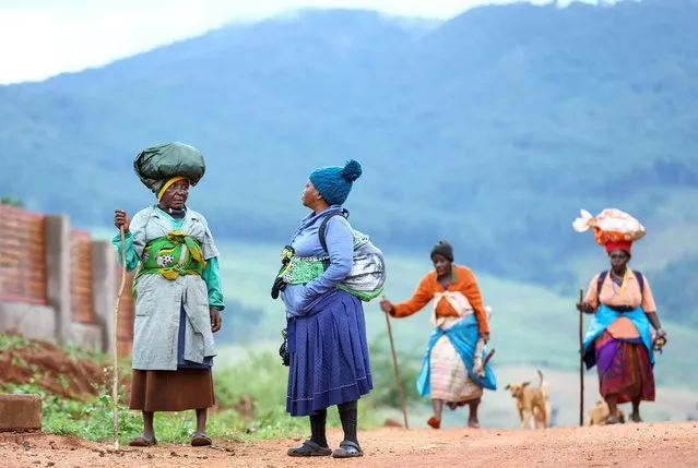 Women chat as others walk using walking sticks, on their return from farming communal land at Tshakhuma village outside Thohoyandou, in Limpopo province, South Africa, April 9, 2022. (Photo by Siphiwe Sibeko/Reuters)