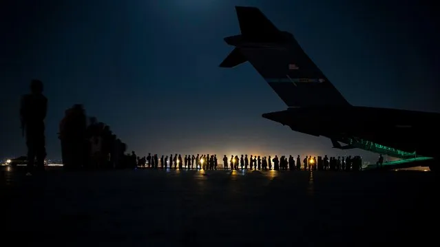 In this image courtesy of the US Air Force, a US Air Force aircrew, assigned to the 816th Expeditionary Airlift Squadron, prepare to load qualified evacuees aboard a US Air Force C-17 Globemaster III aircraft in support of Afghanistan evacuation at Hamid Karzai International Airport, Kabul, Afghanistan, August 21, 2021. President Joe Biden on Sunday said he still hopes to complete the "heartbreaking" evacuation from Afghanistan by the end of the month but warned of potential terrorist attacks against the crowded Kabul airport. (Photo by Aviador senior Taylor Crul/Fuerza Aérea de EU vía AFP Photo)