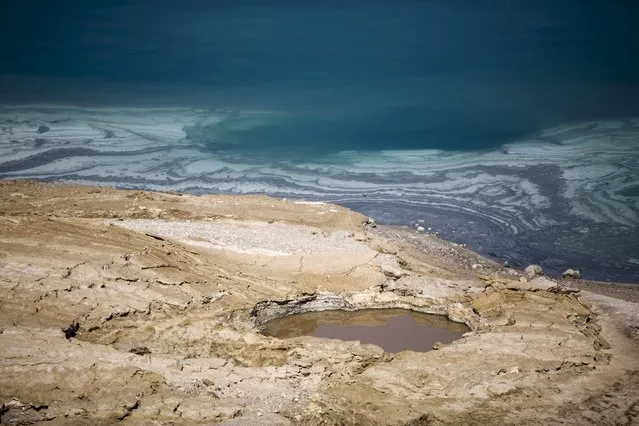 A sinkhole is seen on the shore of the Dead Sea near Kibbutz Ein Gedi, Israel July 27, 2015. The Dead Sea is shrinking, and as its waters vanish at a rate of more than one meter a year, hundreds of sinkholes, some the size of a basketball court, some two storeys deep, are devouring land where the shoreline once stood. (Photo by Amir Cohen/Reuters)