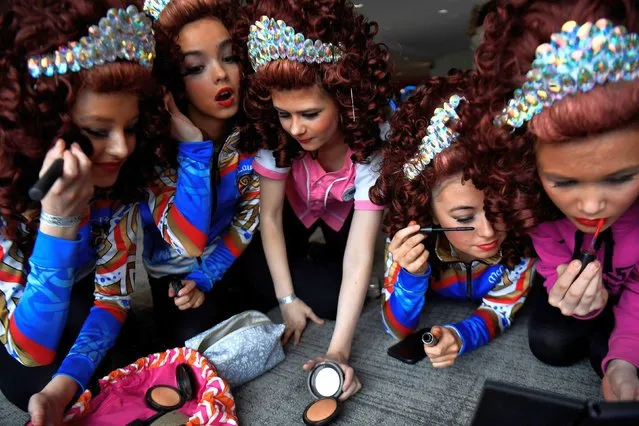Dancers from the McLoughlin school in Glasgow, Scotland put on make-up as they get ready to participate in the 2022 World Irish Dancing Championships on its 50th anniversary, in Belfast, Northern Ireland on April 14, 2022. (Photo by Clodagh Kilcoyne/Reuters)