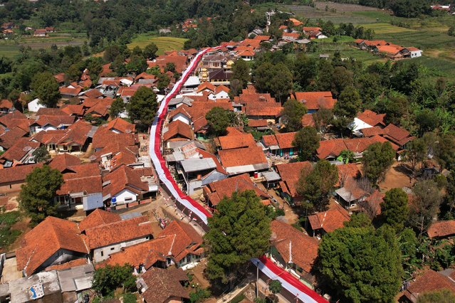 This aerial photo shows a 1000-metre-long red and white cloth, representing the colours of the Indonesian national flag, covering a road ahead of the country's Independence Day on August 17 in Lemahsugih, West Java, on August 7, 2024. (Photo by Timur Matahari/AFP Photo)