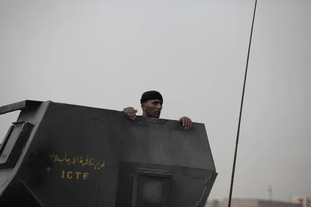 A soldier with Iraq's elite counterterrorism forces peers from the gun turret of a Humvee on the front line in Fallujah, Iraq, Sunday, June 5, 2016. Iraqi forces are pushing their way into the city to retake it from Islamic State militants. (Photo by Maya Alleruzzo/AP Photo)