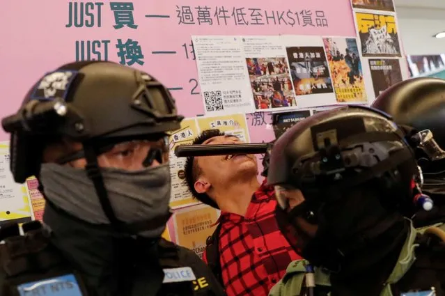 An anti-government protester is hit by police during a demonstration inside a mall in Hong Kong, China on December 15, 2019. (Photo by Danish Siddiqui/Reuters)