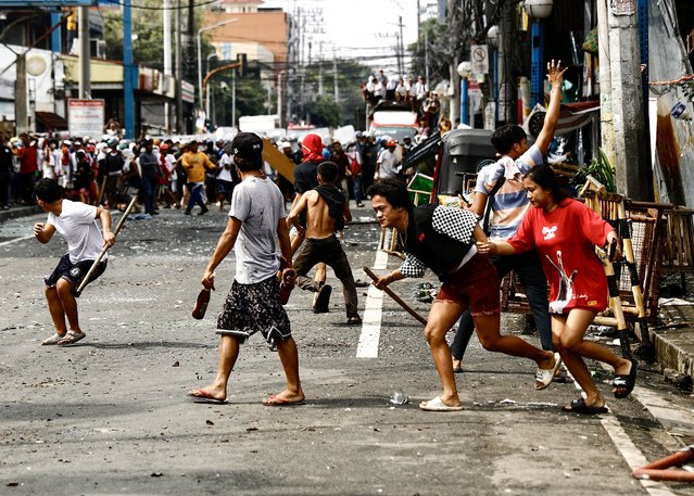 Filipino informal settlers throw rocks and bottles as members of a demolition team and riot police advance during a demolition raid at a shanty town in Pasay City, Metro Manila, Philippines, 01 August 2024. (Photo by Francis R. Malasig/EPA)