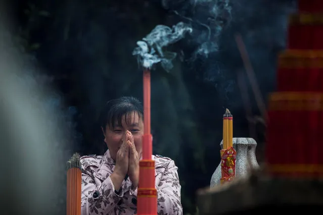 A parent prays at a Confucius statue (unseen) ahead of students taking China's annual National College Entrance Exam in Nantong, Jiangsu Province, China, June 6, 2016. (Photo by Reuters/Stringer)