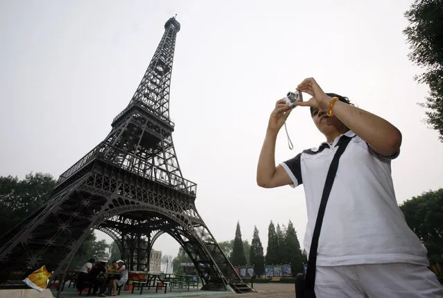 China: A Chinese visitor takes photographs near a replica of the Eiffel Tower at Beijing World Park, one of the three designated “protest parks”, in Beijing July 25, 2008. (Photo by Claro Cortes IV/Reuters)