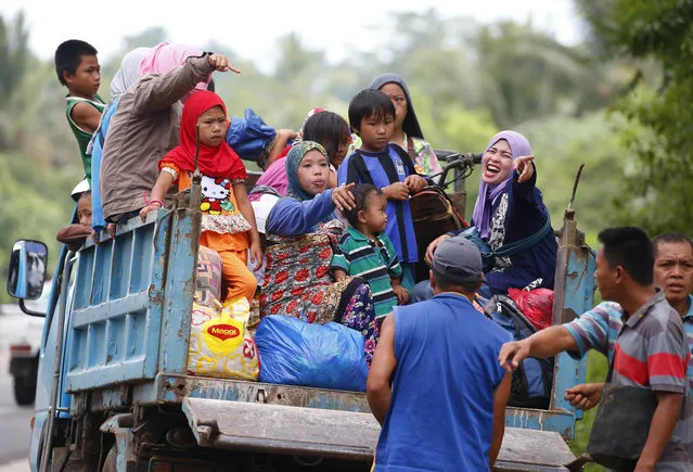 Displaced residents fleeing by a truck to safer areas stop by a roadside as government troops battle with Muslim militants Monday, May 29, 2017 in Marawi, southern Philippines. Philippine forces say they now control most of the southern city where militants linked to the Islamic State group launched a bloody siege nearly a week ago. Presidential Spokesman Ernesto Abella said Monday that only small areas of Marawi are under militants' control. (Photo by Bullit Marquez/AP Photo)