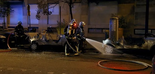 French firemen spray water to extinguish two Autolib' electric cars that were set on fire on a street at the end of a day of nationwide protests against plans to reform French labour laws in Paris, France, June 14, 2016. (Photo by Jacky Naegelen/Reuters)