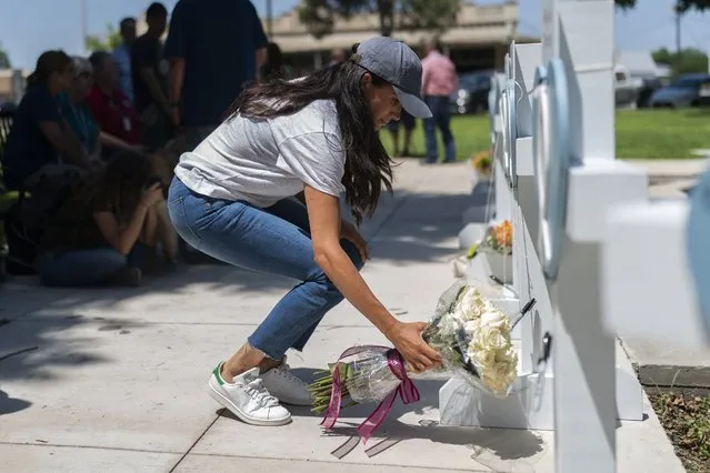 Meghan Markle, Duchess of Sussex, leaves flowers at a memorial site, Thursday, May 26, 2022, for the victims killed in this week's elementary school shooting in Uvalde, Texas. (Photo by Jae C. Hong/AP Photo)