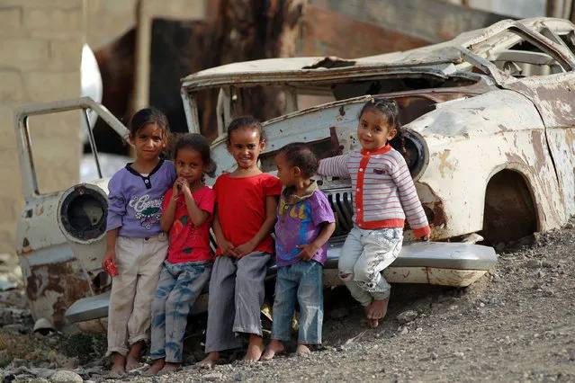 Yemeni children play next to the wreckage of a car on June 15, 2016 in an empoverished part of the capital Sanaa. Yemen's warring parties are struggling to seal a peace deal as mutual mistrust has overshadowed eight weeks of UN-brokered talks in Kuwait that have failed to achieve any major breakthrough. (Photo by Mohammed Huwais//AFP Photo)