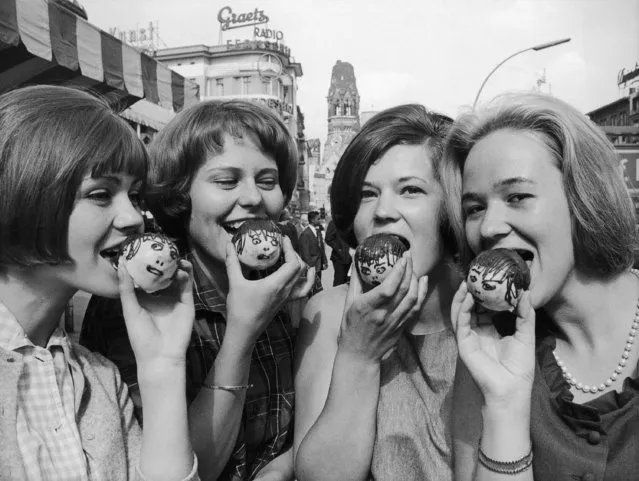 Beatles fans eat cakes designed to looks like each member of the Beatles which were baked by a pastry shop on the Kurfuerstendamm in Berlin, Germany on June 9, 1964. (Photo by AP Photo/Reichert)