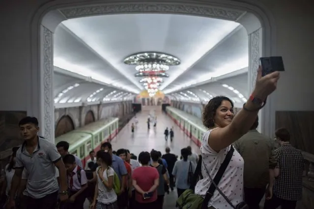 A tourist takes a selfie during a visit to a subway station in Pyongyang on July 23, 2017. The Westerners lined up before giant statues of North Korea's founder Kim Il-Sung and his son and successor Kim Jong-Il on Sunday and, on command from their guide, bowed deeply – a ritual that the Trump administration intends to stop US tourists performing, with Washington due to impose a ban on its citizens holidaying in the Democratic People's Republic of Korea (DPRK), as the North is officially known. (Photo by Ed Jones/AFP Photo)