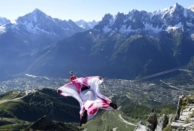 Switzerland's Geraldine Fasnacht jumps from the top of the Brevent mountain to fly in wingsuit over the French ski resort of Chamonix on July 16, 2014. (Photo by Philippe Desmazes/AFP Photo)