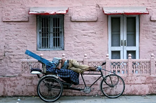 A cycle rickshaw puller sleeps by the roadside in Ajmer, in the desert state of Rajasthan, India June 23, 2016. (Photo by Himanshu Sharma/Reuters)