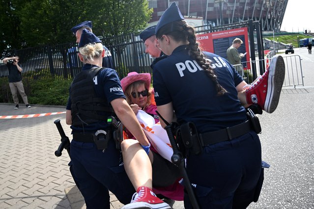 Polish police officers carry away an environmental activist (C) dressed as a fan of US singer Taylor Swift and blocking the entrance to the National Stadium hosting a three-day performance of the pop star in Warsaw, Poland, on August 2, 2024. The activists accuse the US singer of being “detached” from environmental issues. (Photo by Sergei Gapon/AFP Photo)
