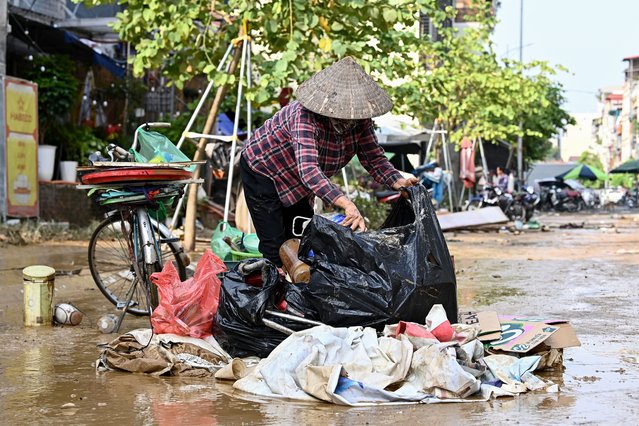 A resident cleans up after flood waters receded in Hanoi on September 13, 2024. (Photo by Nhac Nguyen/AFP Photo)