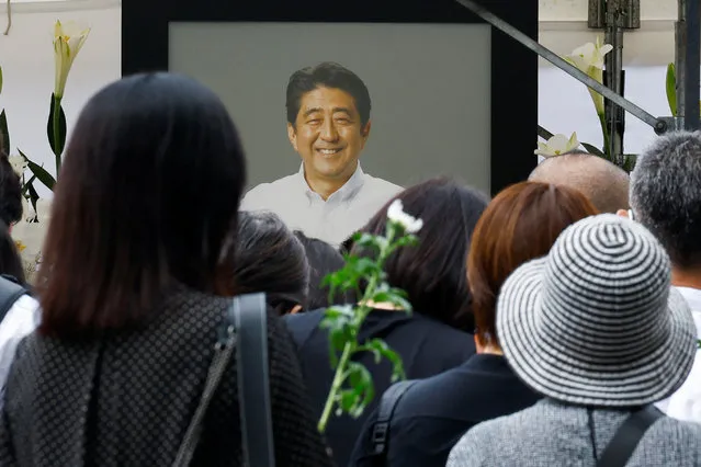 People gather to offer flowers at Zojoji Temple, where the funeral of late former Japanese Prime Minister Shinzo Abe, who was shot while campaigning for a parliamentary election, will be held, in Tokyo, Japan on July 12, 2022. (Photo by Kim Kyung-Hoon/Reuters)