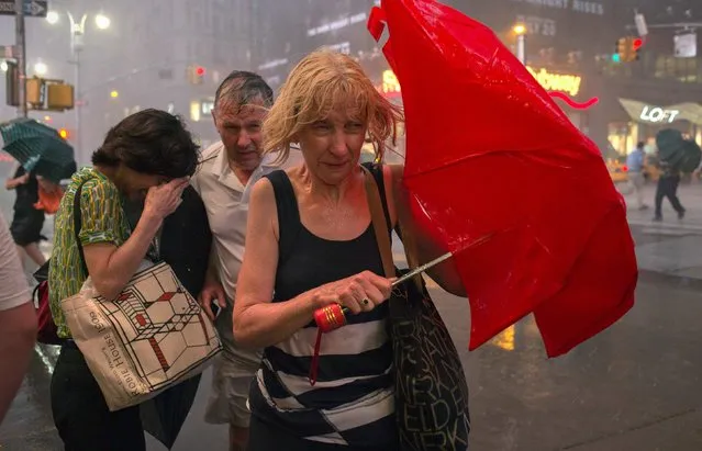 Commuters dodge high wind and heavy rain during a thunderstorm in midtown Manhattan, in New York July 18, 2012. (Photo by Adrees Latif/Reuters)