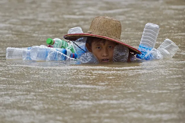 A flood-affected resident swims in floodwaters at Kyaut Ye village near the Hinthada town in Myanmar's Irrawaddy region on August 11, 2015. (Photo by Ye Aung Thu/AFP Photo)