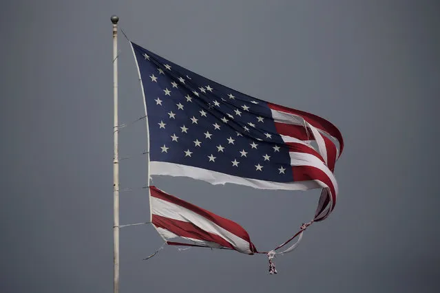A tattered U.S. flag damaged in Hurricane Harvey, flies in Conroe, Texas, U.S., August 29, 2017. (Photo by Carlo Allegri/Reuters)
