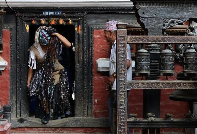 A Nepalese Buddhist devotee wears a mask takes part in the Neku Jatra-Mataya festival in Patan in Kathmandu, August 12, 2014. The Buddhist festival marks the victory of Sakyamuni Buddha over Mara, where devotees pray for the souls of departed family members and hold parades throughout the city. (Photo by Prakash Mathema/AFP Photo)