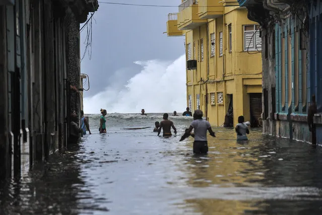 Cubans wade through a flooded street near the Malecon in Havana, on September 10, 2017. Deadly Hurricane Irma battered central Cuba on Saturday, knocking down power lines, uprooting trees and ripping the roofs off homes as it headed towards Florida. Authorities said they had evacuated more than a million people as a precaution, including about 4,000 in the capital. (Photo by Yamil Lage/AFP Photo)