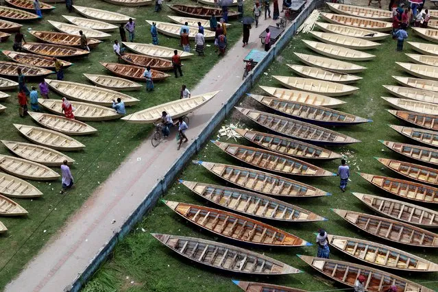 Hundreds of small wooden boats are lined up for sale at the Ghior boat market in Manikganj on June 29, 2022. It is the largest boat market in Bangladesh. As these areas are submerged in rain water, the locals use these boats during the monsoon season. It is a centennial boat hut. Boats are sold here for tk 1200 ($13) to tk 8000. (Photo by Syed Mahabubul Kader/ZUMA Press Wire/Alamy Live News)