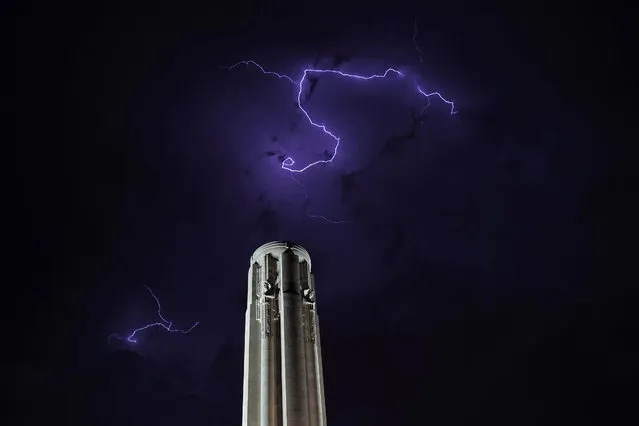 Lightning flashes above the Liberty Memorial tower as a thunderstorm passes in the distance Saturday, June 11, 2022, in Kansas City, Mo. The 217-foot-tall tower is part of larger museum and memorial complex honoring those who fought in World War I. (Photo by Charlie Riedel/AP Photo)