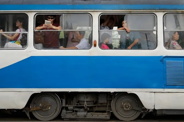 Commuters ride in an electric trolley in downtown Pyongyang, North Korea on July 28, 2017. (Photo by Wong Maye-E/AP Photo)