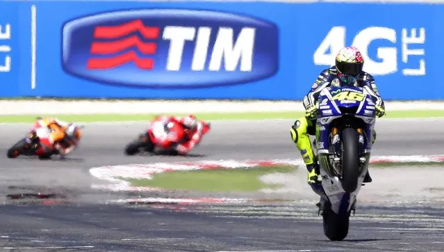 Yamaha MotoGP rider Valentino Rossi performs a wheelie as he crosses the finish line to win the San Marino Grand Prix in Misano Adriatico circuit in central Italy September 14, 2014. (Photo by Max Rossi/Reuters)