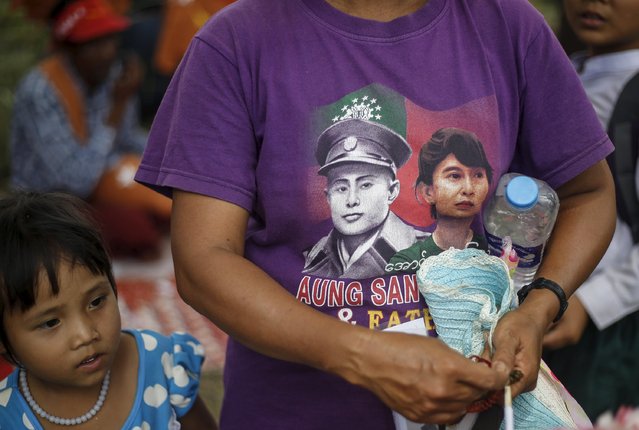 A woman, wearing a T-shirt depicting an image of Myanmar pro-democracy leader Aung San Suu Kyi (R) and her father Myanmar national hero General Aung San, stands during Suu Kyi's speech in Demoso, Kayah state September 10, 2015. (Photo by Soe Zeya Tun/Reuters)
