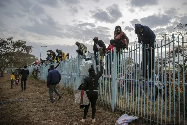 People climb over barriers causing a stampede as they try to force their way into Kasarani stadium where the inauguration of Kenya's new president William Ruto is due to take place later today, in Nairobi, Kenya Tuesday, September 13, 2022. (Photo by Brian Inganga/AP Photo)
