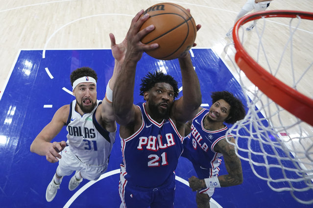 Philadelphia 76ers' Joel Embiid, center, pulls in a rebound between Dallas Mavericks' Klay Thompson, left, and Kelly Oubre Jr. during the second half of an NBA basketball game, Tuesday, February 4, 2025, in Philadelphia. (Photo by Matt Slocum/AP Photo)