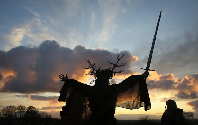 A man representing the Winter King holds a sword as he takes part in a sunset ceremony as they celebrate Samhain at the Glastonbury Dragons Samhain Wild Hunt 2017 in Glastonbury on November 4, 2017 in Somerset, England. (Photo by Matt Cardy/Getty Images)