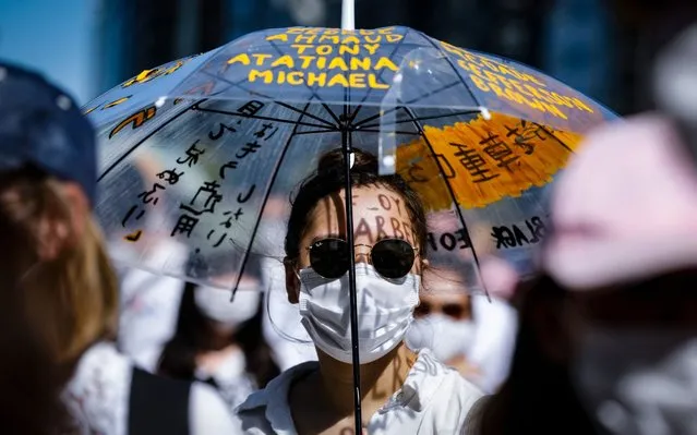 A woman wearing a face mask holds up an umbrella as she joins a protest against the killing of George Floyd, an unarmed African American man killed by police in Minneapolis, in Osaka city, western Japan, 07 June 2020. Some 700 protesters attended the rally organized by supporters of the Black Lives Matter movement in Japan as it took place amid coronavirus pandemic despite of criticism that such a gathering would increase the risk of further spreading of the infection. A Japanese tennis star Naomi Osaka, who was born in Osaka city, expressed her support for the protest on her Twitter account. (Photo by Dai Kurokawa/EPA/EFE)