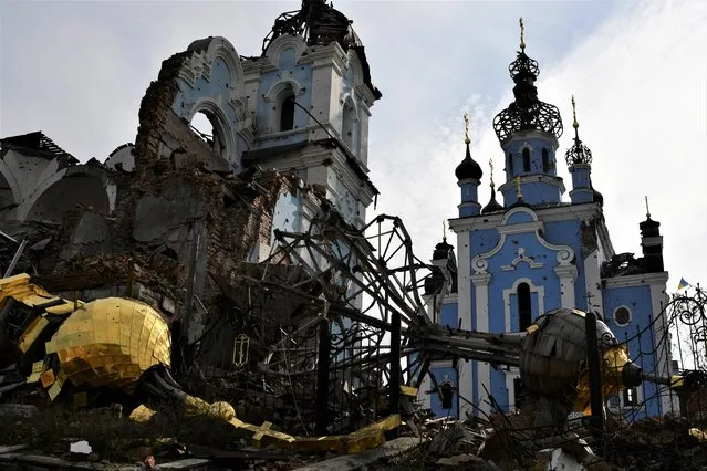 Destroyed domes lie next to a damaged church in the retaken village of Bohorodychne, eastern Ukraine, Saturday, October 22, 2022. (Photo by Andriy Andriyenko/AP Photo)