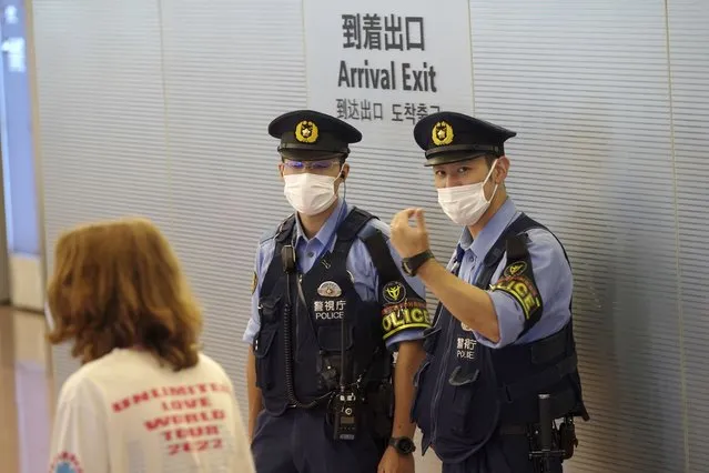 Police officers stand guard at international arrival exit at the Haneda International Airport Tuesday, October 11, 2022, in Tokyo. Japan's strict border restrictions are eased, allowing tourists to easily enter for the first time since the start of the COVID-19 pandemic. Independent tourists are again welcomed, not just those traveling with authorized groups. (Photo by Eugene Hoshiko/AP Photo)