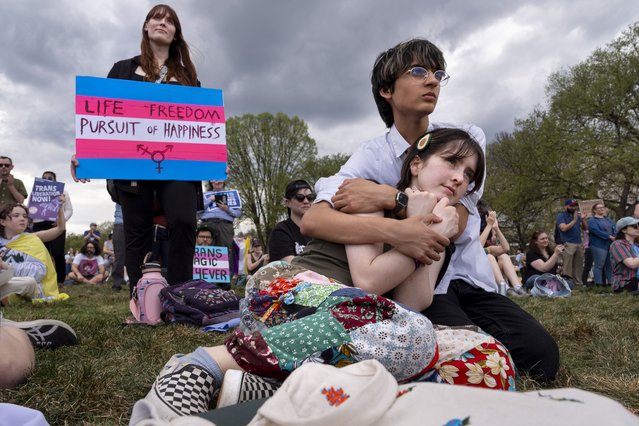 Lily Travis, 18, and Noah Masom, 17, both of northern Virginia, hug while attending a rally in support of people who are transgender during the Trans Day of Visibility, on the National Mall, Monday, March 31, 2025, in Washington. “I'm not the biggest protester, but I wanted to show my friends that their struggles are important”, says Masom, “they need to know that people are on their side”. (Photo by Jacquelyn Martin/AP Photo)