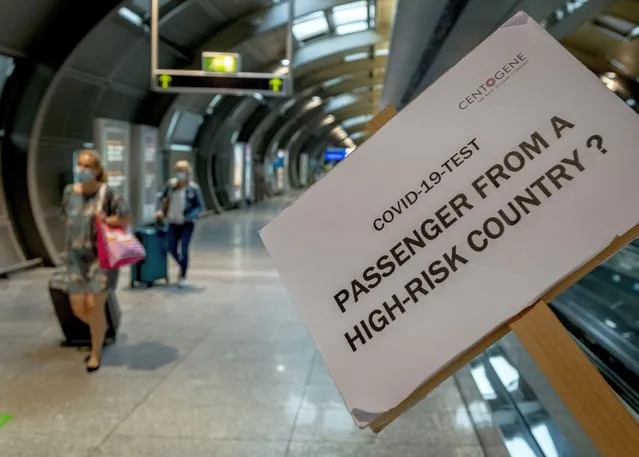 A sign helps passengers to find the Cover-19 test center at the airport in Frankfurt, Germany, Saturday, August 8, 2020. From Saturday on Covid-19 tests are mandatory for passengers coming from a high-risk-country. (Photo by Michael Probst/AP Photo)