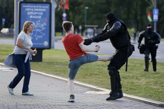 Police officer detains a a young demonstrator during a mass protest following presidential elections in Minsk, Belarus, Monday, August 10, 2020. (Photo by Sergei Grits/AP Photo)