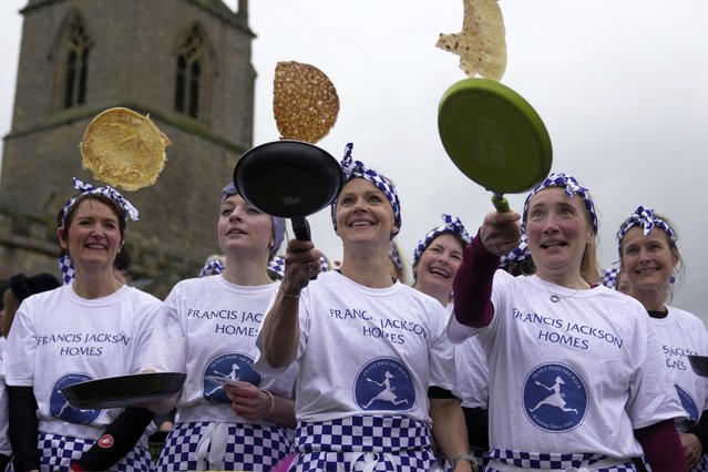 Pancake race winner Kaisa Larkas, center, and second place finisher Eloise Kramer, second left, and third place finisher Rebecca Budd, second right, celebrate after the annual Shrove Tuesday trans-Atlantic pancake race in the town of Olney, in Buckinghamshire, England, Tuesday, February 13, 2024. Every year women clad in aprons and head scarves from Olney and the city of Liberal, in Kansas, USA, run their respective legs of the race with pancakes in their pans. According to legend, the Olney race started in 1445 when a harried housewife arrived at church on Shrove Tuesday still clutching her frying pan with a pancake in it. (Photo by Kin Cheung/AP Photo)