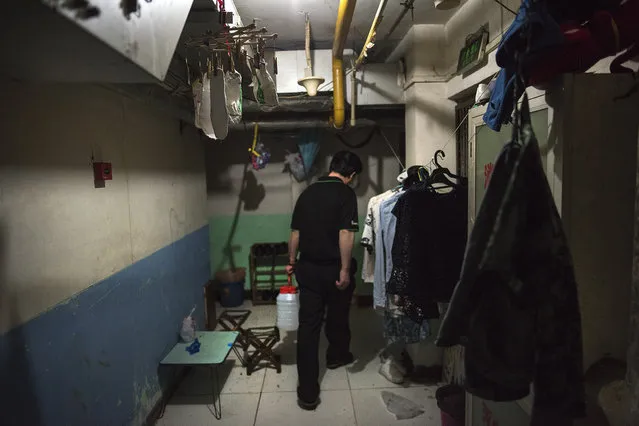 A man carries water to his room in a basement dwelling in Beijing on May 23, 2016. (Photo by Michael Robinson Chavez/The Washington Post)
