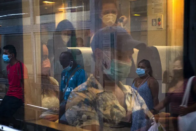 Passengers wearing face masks travel on a train at the main train station in Barcelona, Spain, on Friday, August 28, 2020. Spanish authorities have announced new restrictions to prevent COVID-19. (Photo by Emilio Morenatti/AP Photo)