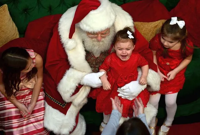 A girl cries while taking photos with Santa Claus at the King of Prussia Mall on December 11, 2022 in King of Prussia, Pennsylvania. The country's largest retail shopping space, the King of Prussia Mall, a 2.7 million square feet shopping destination with more than 400 stores, is owned by Simon Property Group. (Photo by Mark Makela/Getty Images)