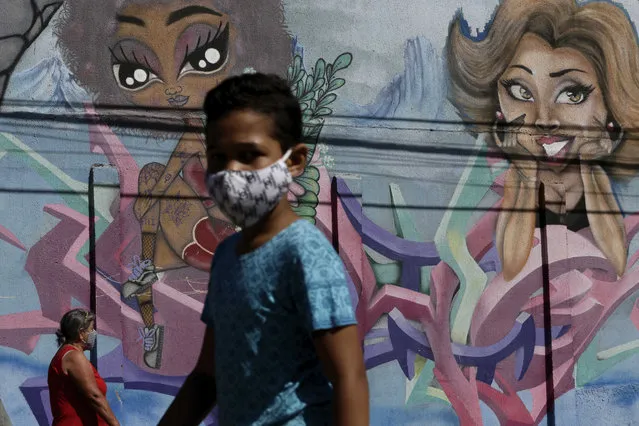People wear masks amid the COVID-19 pandemic in Ceilandia, one of the neighborhoods most affected by COVID-19 in Brasilia, Brazil, Tuesday, July 21, 2020. (Photo by Eraldo Peres/AP Photo)
