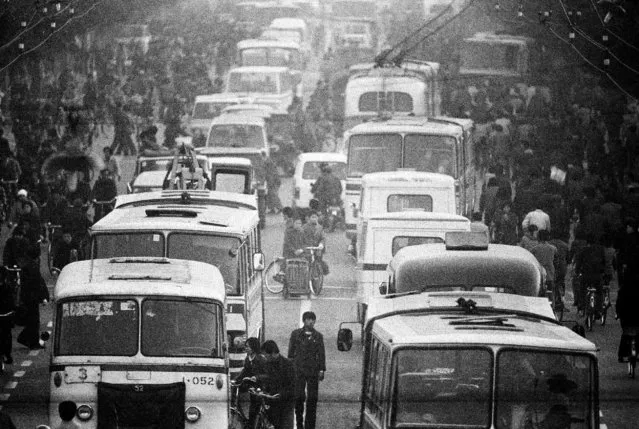 Buses and electrical trolley buses mingle with bicycles and pedestrians at a crossroad near Chongwenmen in Beijing in 1984. (Photo by Reuters/China Daily)