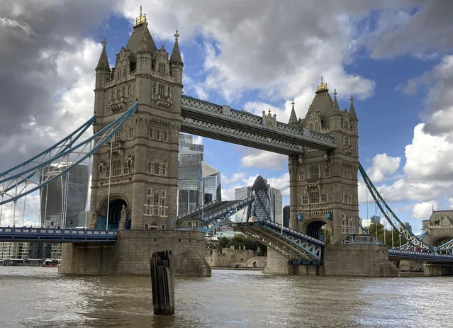 Tower Bridge crossing the River Thames is stuck open, leaving traffic in chaos and onlookers stunned as the iconic river crossing remains open, in London, Saturday August 22, 2020. The historic bridge has failed to close Saturday after opening to allow ships to pass underneath on the River Thames. (Photo by Tony Hicks/AP Photo)
