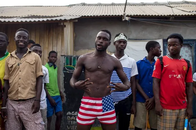 A resident of Jamestown nicknamed "Super Scary" dances to music played by DJ Evans Mireku Kissi during a street performance in Jamestown, Accra, Ghana, June 12, 2015. (Photo by Francis Kokoroko/Reuters)